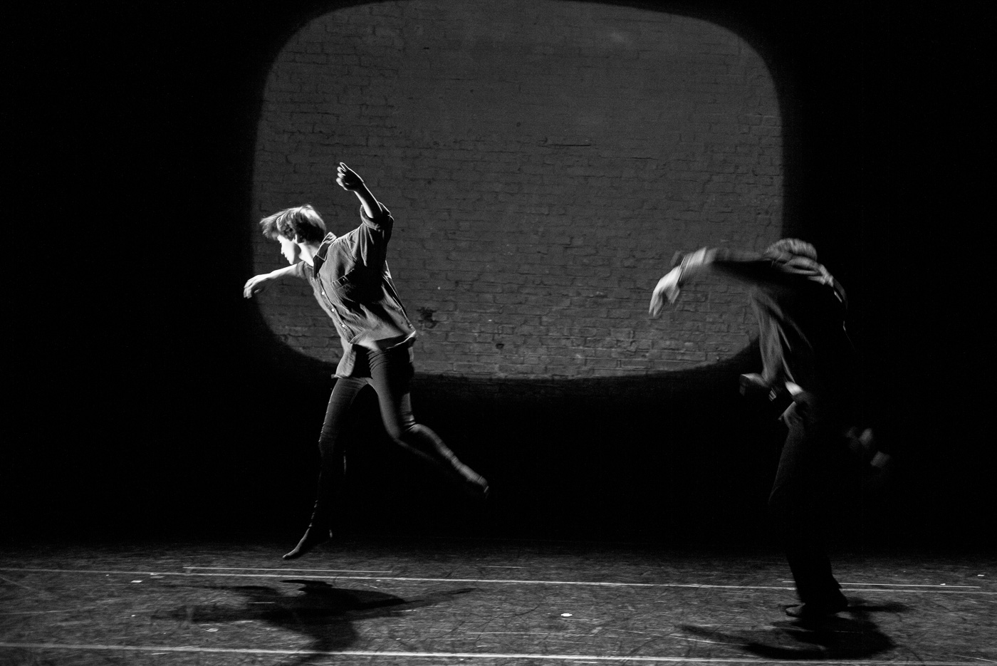 Black and white photo of Paul dancing with Eleanor Perry they are leaping energetically
